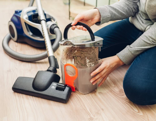 Pessoa limpando o aspirador de pó.