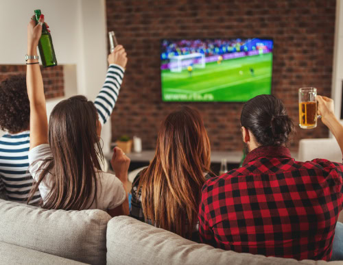 Qual é a melhor TV para assistir futebol em casa? Confira! 1 Três amigos vendo jogo de futebol.