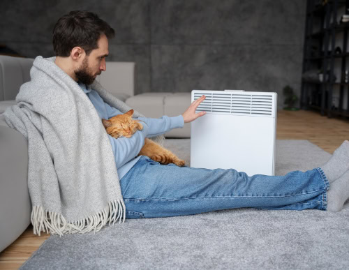 Ar-condicionado ou climatizador? Guia completo para escolher o melhor para a sua casa 1 Homem ao lado do aquecedor.