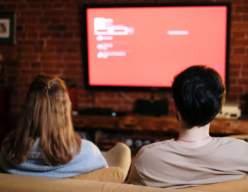 Tamanho de TV ideal: como escolher para cada ambiente 1 Casal assistindo TV.