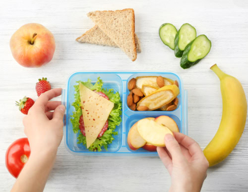 Lanches saudáveis para escola: opções práticas e nutritivas 1 Lancheira sendo montada com frutas, nuts e salada.